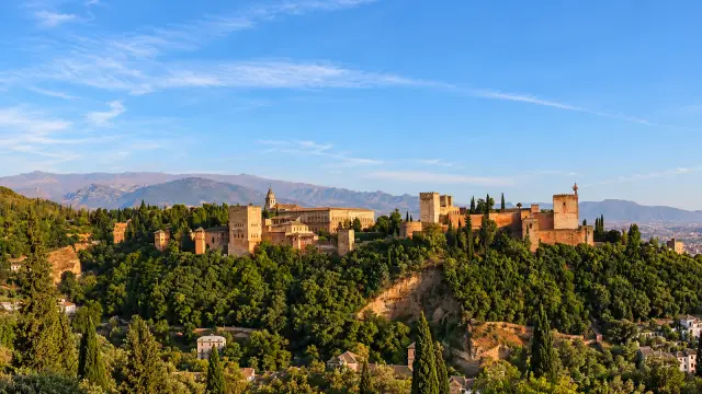 The Alhambra seen from the Mirador de San Nicolás in Granada, in late-afternoon light, with the Sierra Nevada behind