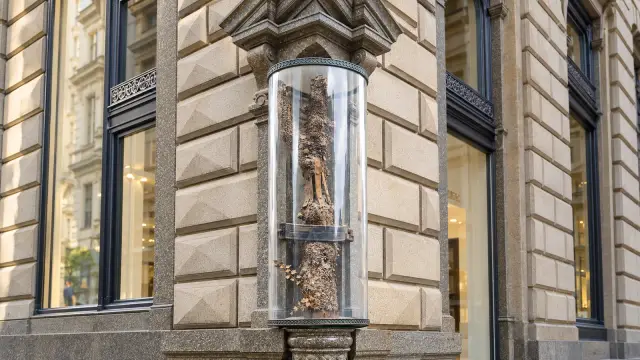 Vienna's Stock im Eisen: a tree trunk covered in nails, with an iron band and padlock, in a granite niche