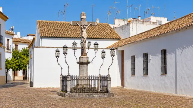 The Cristo de los Faroles in Córdoba's Plaza de Capuchinos, ringed by iron lanterns between whitewashed walls
